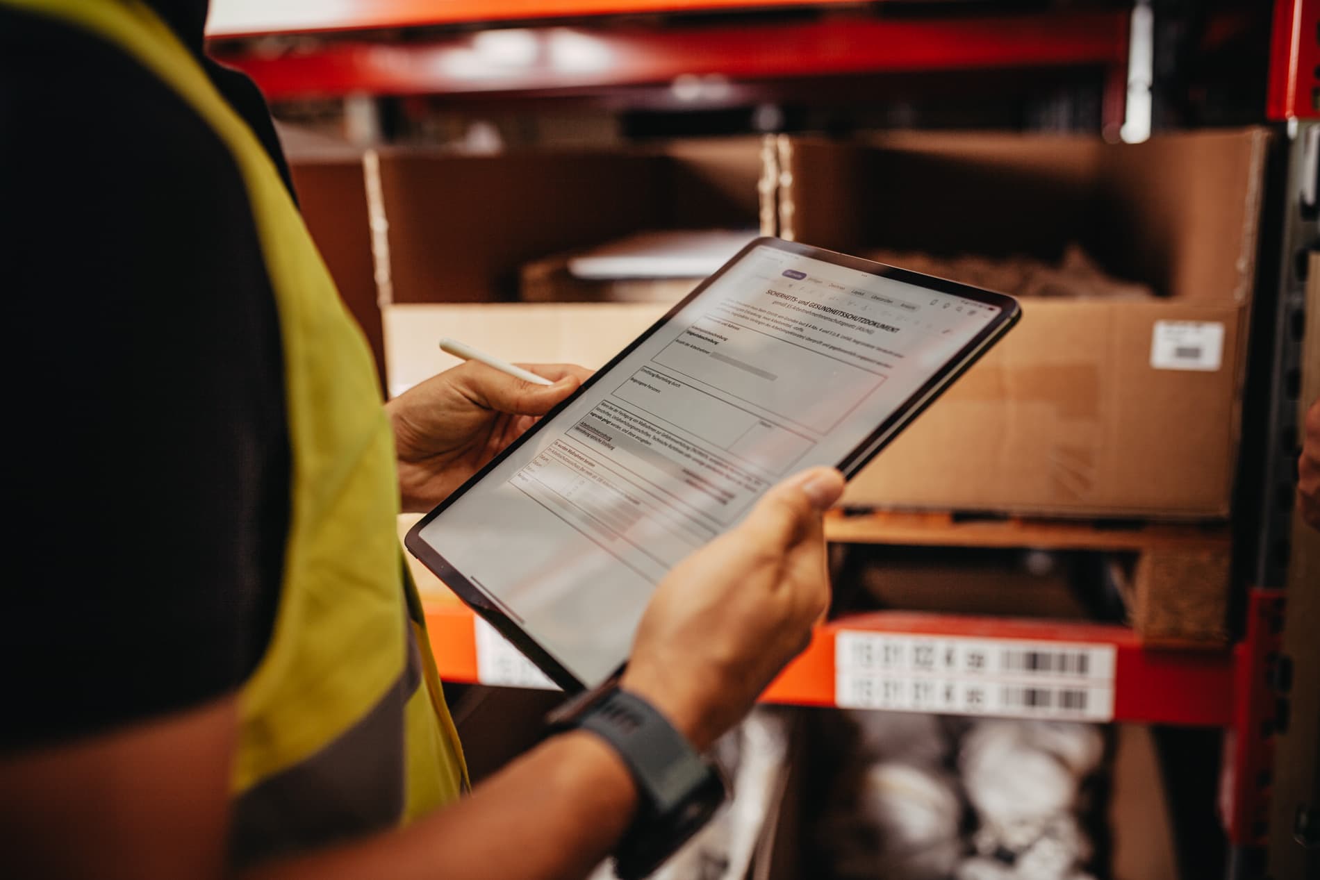 Lagermitarbeiter prüft ein Sicherheits- und Gesundheitsschutzdokument auf einem Tablet